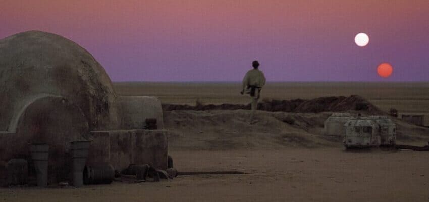 Luke Skywalker walking towards the twin sunset of desert planet Tatooine.